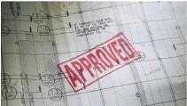 A blueprint with the word Approved stamped on it in red ink