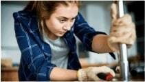 A woman doing some handywork with a pipe