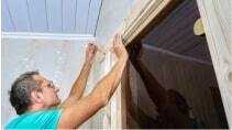 A man doing some work on a door frame