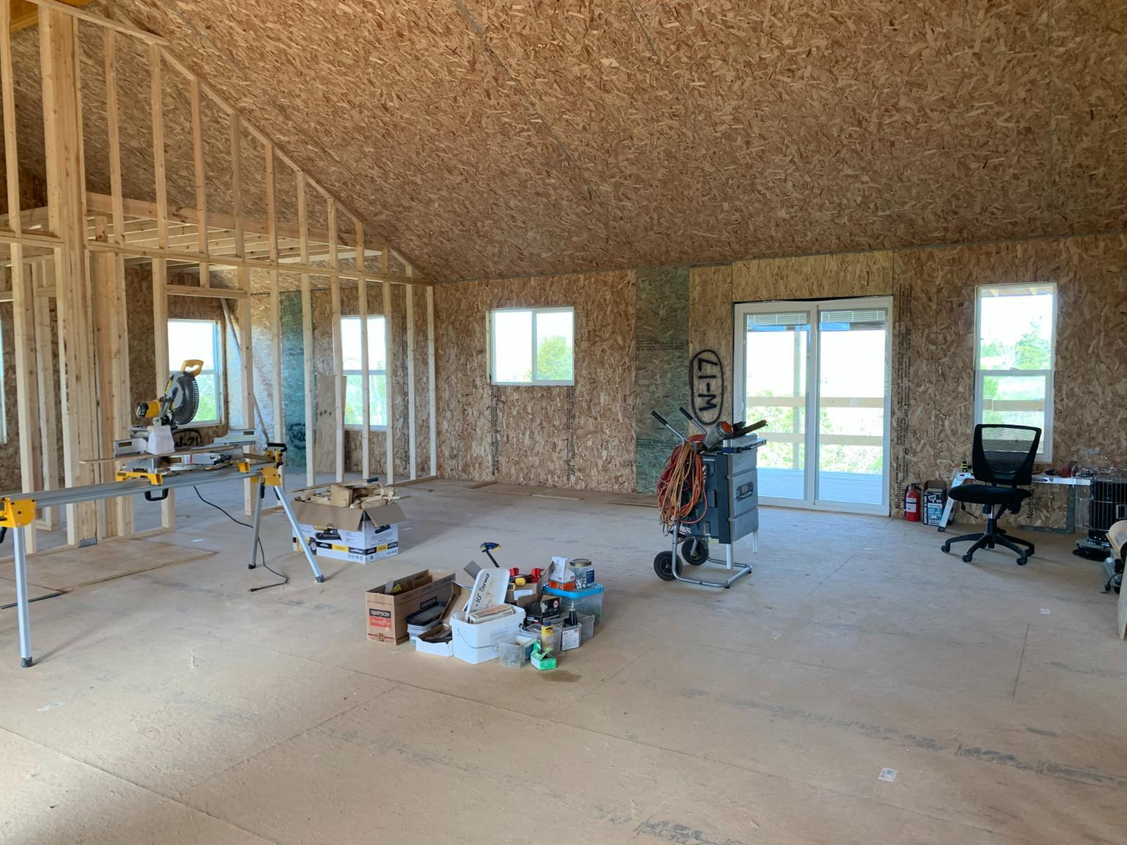 An interior view of a house under construction with framing for rooms and windows.